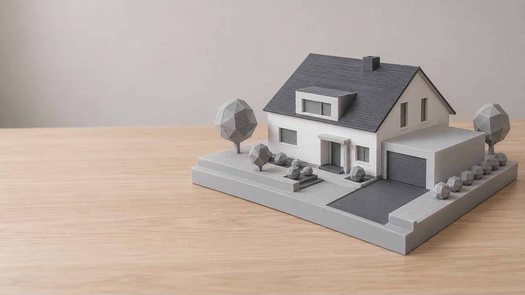 Hausmodell eines Einfamilienhauses mit Satteldach, Gaube und Garage, ganz in Weiß und Grau mit stilisierten Bäumen